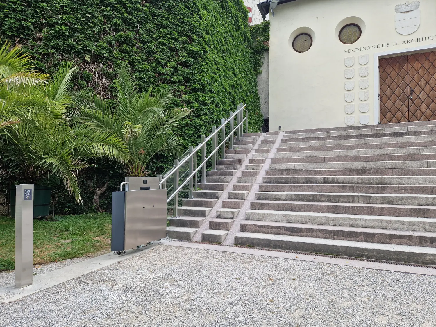 Plattformlift überwindet Stufen am Hauseingang mit Rollstuhl